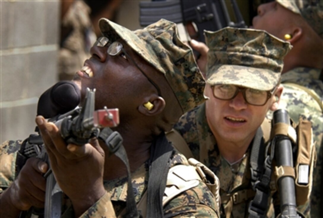 U.S. Marine Staff Sgt. Martinez Francois, left, and Pvt. Brian Brock, both from  the 4th Civil Affairs Group, take cover after a bomb exploded in a mock village during civil-military operations training at Marine Corps Base Quantico, Va., Aug. 9, 2006.  
