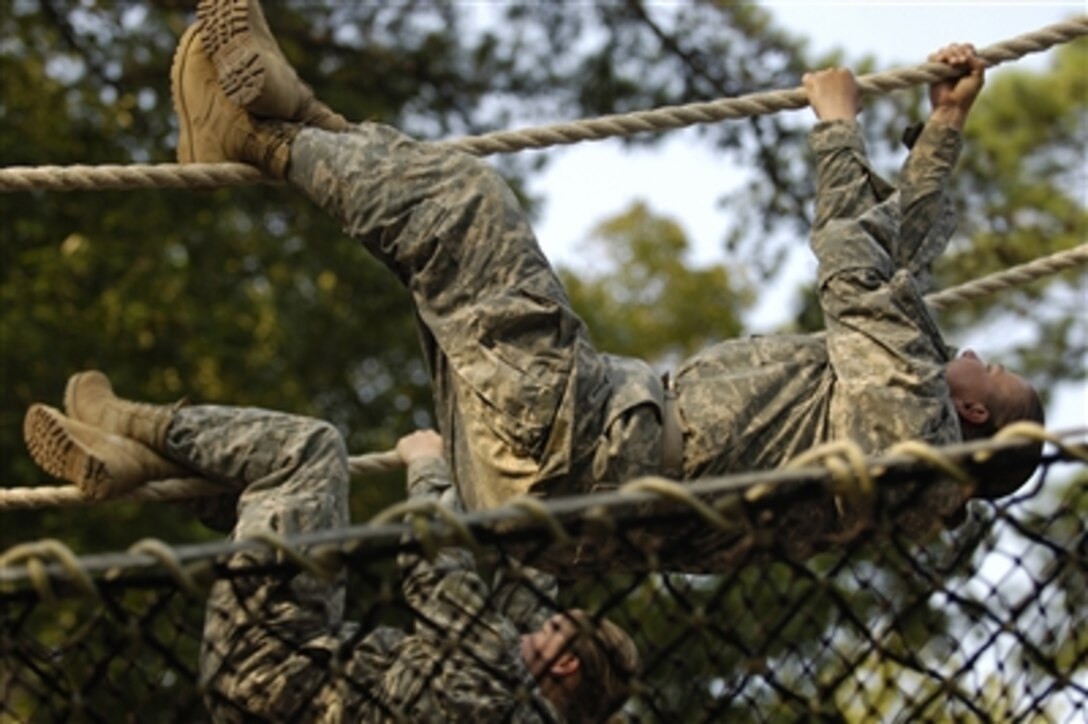 U.S. Army recruits shuffle down a rope obstacle on the confidence course during basic combat training at Fort Jackson, S.C., on Aug. 8, 2006.    