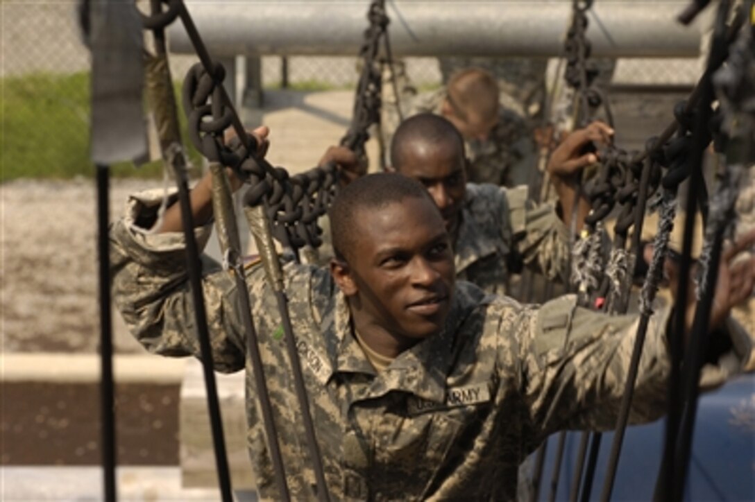 U.S. Army privates traverse a rope bridge as they compete in the Victory Tower course during basic combat training on Fort Jackson, S.C., on Aug. 9, 2006.  The training is nine-weeks in length and is divided into red, white and blue phases.