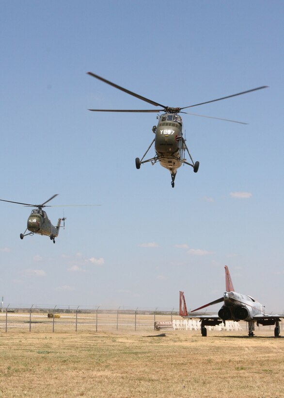 The Flying Memorial, Ugly Angels 'Yankee Lima' 37 and 38, restored H-34 Sea Horses that saw more than their share of combat time in the Vietnam War, make their final approach to the future home of the Close Air Support Aircraft Veterans' Memorial Airpark during the 3rd Annual Cowtown Warbird Roundup held at Meacham Airport in Fort Worth, Texas, Aug. 11 and 12. Below them, a test and evaluation VX-30 colored QF-4S Phantom with a combat history of it own. The event benefited the OV-10 Bronco Association, Forward Air Controller's Museum and the Vintage Flying Museum. Photo by Gunnery Sgt. Rusty Baker