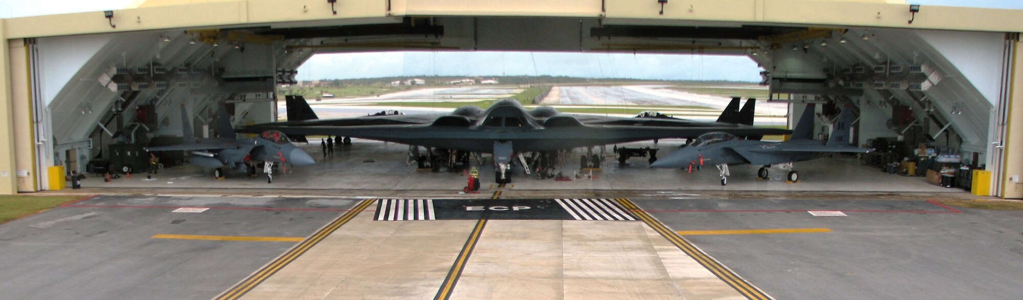 Two B-2 Spirit bombers and four F-15E Strike Eagles are parked inside Hangar 1 at Andersen Air Force Base, Guam, Aug. 6. The aircraft were moved into the hangar in preparation for a tropical storm that was expected to reach Guam that day. This was the first time the six aircraft had been parked in the hangar, proving to base officials that the hangar could accommodate the aircraft, and aiding in future tropical storm and typhoon planning. The two bombers are deployed to the 13th Expeditionary Bomb Squadron from the 509th Bomb Wing at Whiteman AFB, Mo. The fighters are deployed to the 90th Expeditionary Fighter Squadron from the 3rd Wing at Elmendorf AFB, Alaska. (U.S. Air Force photo illustration/Tech. Sgt. Mikal Canfield)