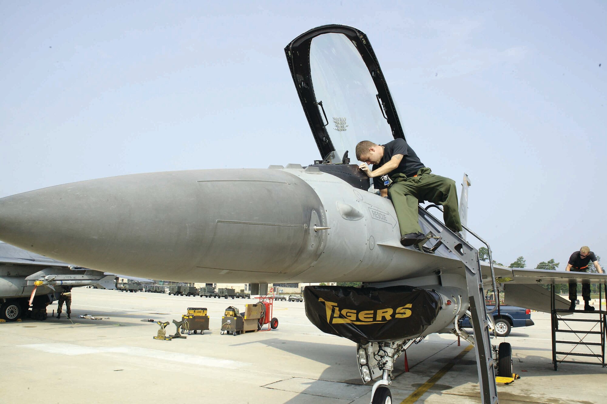 Senior Airman Flood pulls the ejection seat safety pins and prepares the cockpit for the pilot before he steps to the jet.  (U.S. Air Force photo/Senior Airman Holly MacDonald)
