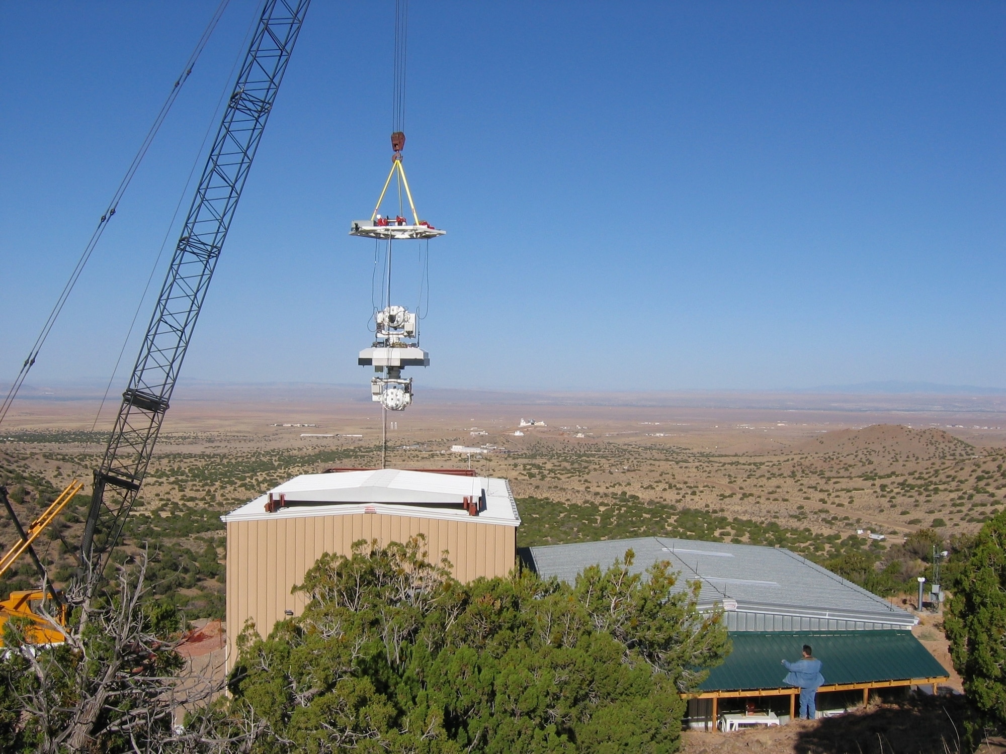 KIRTLAND AIR FORCE BASE, N.M. — A dual-mirror system, called the Aerospace Relay Mirror System, suspended from a crane at 100 feet above the ground, is being tested here. The system is a prototype designed to extend the range of high-energy lasers by receiving and redirecting laser energy. Developed at the Air Force Research Laboratory’s Directed Energy Directorate, an operational version might be suspended from a high-altitude airship at an altitude of 70,000 feet, where atmospheric turbulence, or jitter, is less of a problem for beam quality. (Air Force photo)