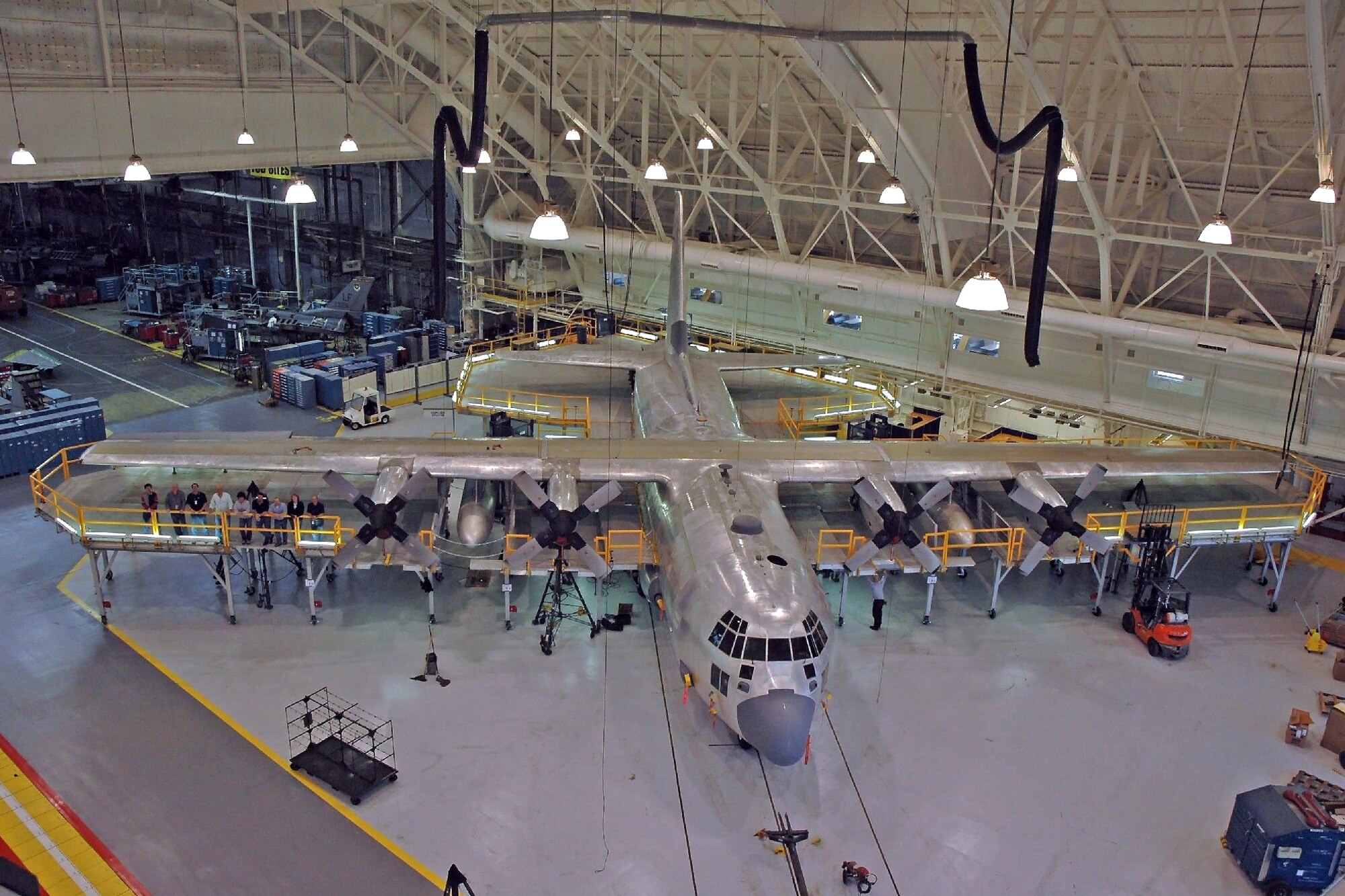 HILL AIR FORCE BASE, Utah — An aerial view shows how the work stand is fitted around the C-130s wing and tail area. The black tubing above brings fresh-air heating and cooling to the work area, reducing ground clutter around the aircraft. (Air Force photo by Tom Whitney)