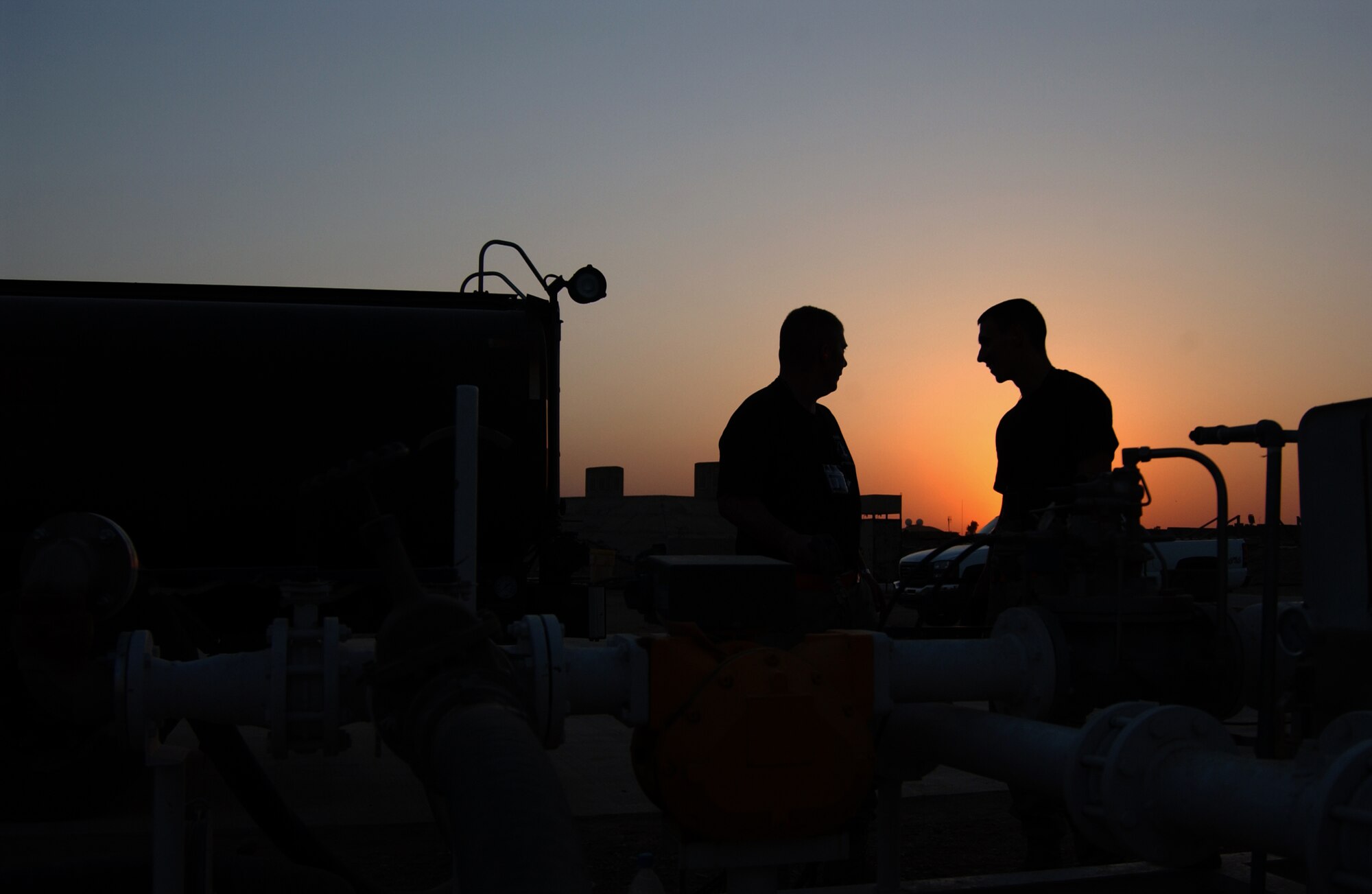 BALAD AIR BASE, Iraq -- Tech Sgt. Daniel Glore, left, and Staff Sgt. William Ryan, 332nd Expeditionary Logistics Readiness Squadron, oversee the aviation gas system as it refills a fuel truck. The fuels flight of the 332nd ELRS pumps 12 million gallons of gas every four months. (U.S. Air Force photo/Senior Airman Kerry Solan-Johnson)                                                             
