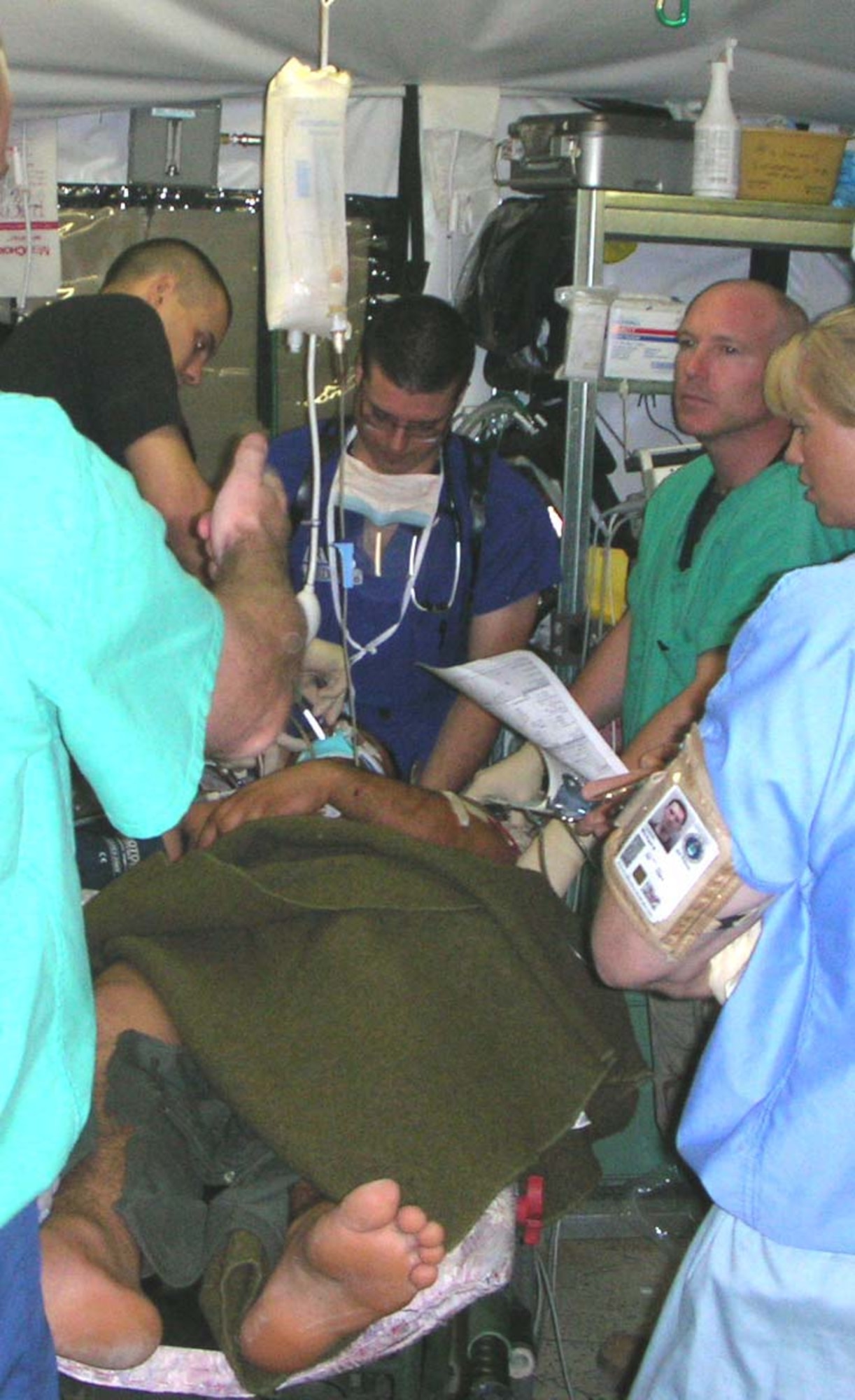 BALAD AIR BASE, Iraq -- Capt. (Dr.) Paul DeFlorio (center) works to save the life of an Iraqi soldier with a gunshot wound to the head Aug. 7.  As an emergency room doctor at the Air Force Theater Hospital here, Major DeFlorio administers medical aid to all war-wounded patients regardless if they are Americans, Iraqis, civilians, or even insurgents.  Patients are prioritized based on the severity of their injuries and not their religious or political differences.  (U.S. Air Force photo by Lt. Col. Bob Thompson)    