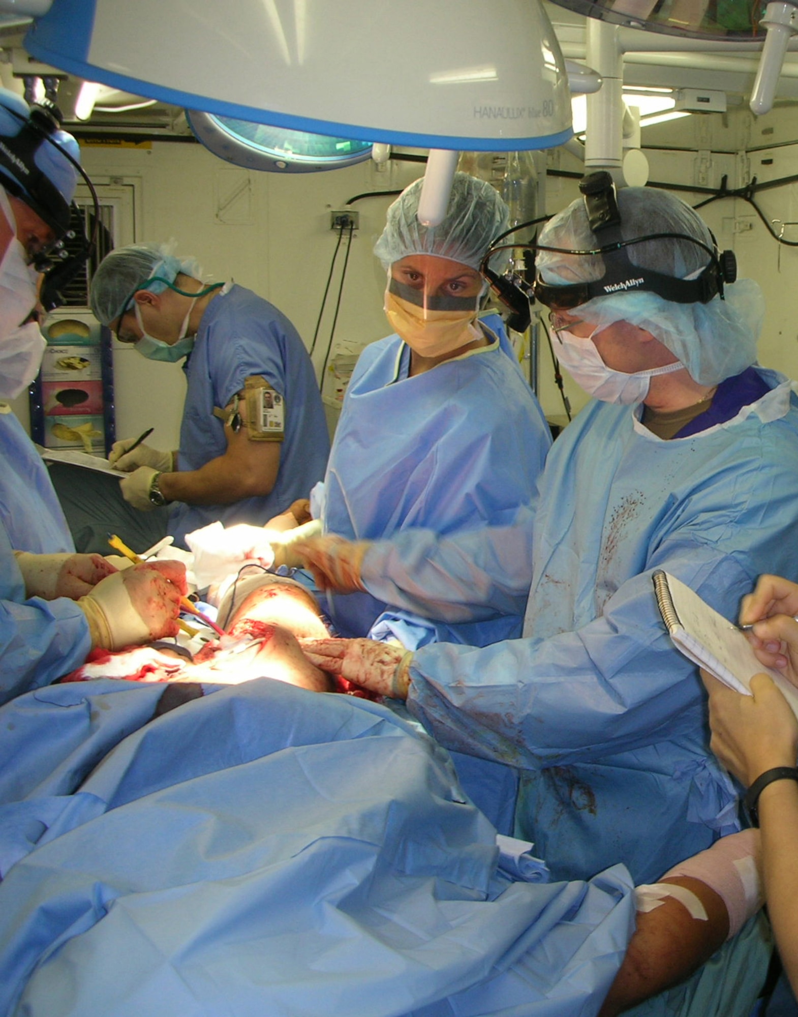 BALAD AIR BASE, Iraq -- Maj. (Dr.) Cabot Murdock (right), vascular surgeon at the Air Force Theater Hospital, works to repair the blood vessels in the thigh of an insurgent wounded and captured Aug. 7.  Performing more than 1,200 surgical procedures in July, Major Cabot and his fellow surgeons assigned to the 332d Expeditionary Medical Group nearly doubled the count from three months earlier.  This increase is attributed to an increase in Iraqi patients at the hospital who require more extended care compared to the Americans who are aeromedically evacuated to Germany and the United States as quickly as possible. (U.S. Air Force photo by Lt. Col. Bob Thompson)           