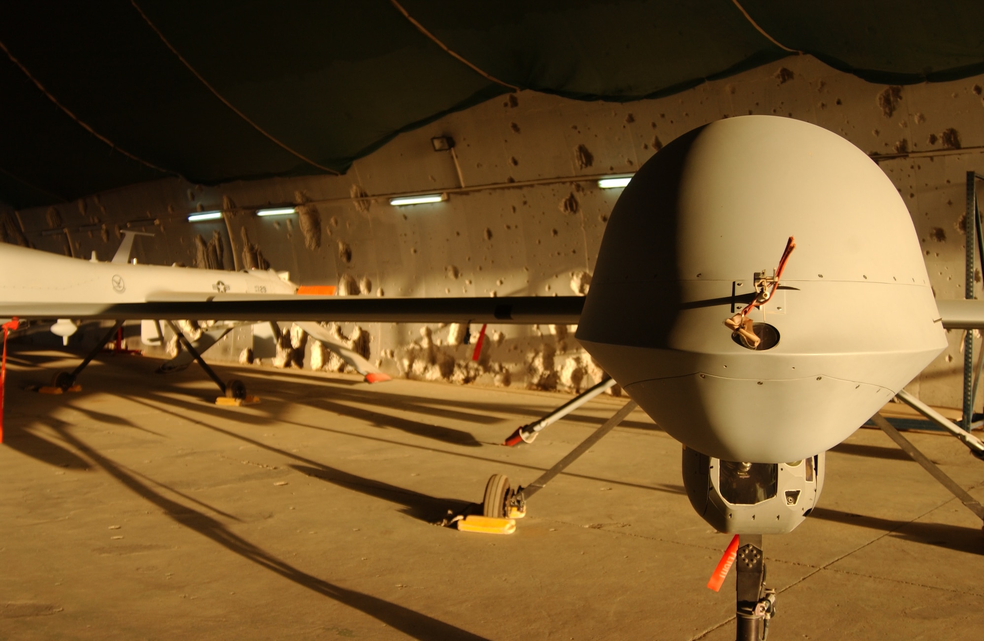 An MQ-1 Predator sits in a hardened aircraft shelter Monday at Balad Air Base, Iraq.  The 332d Air Expeditionary Wing here is home to the largest operational Predator squadron in the world, operating about 20 of the aircraft.  The shelter still bears the pock marks from U.S. attacks at the opening of Operation Iraqi Freedom (U.S. Air Force photo/SrA Kerry Solan-Johnson).