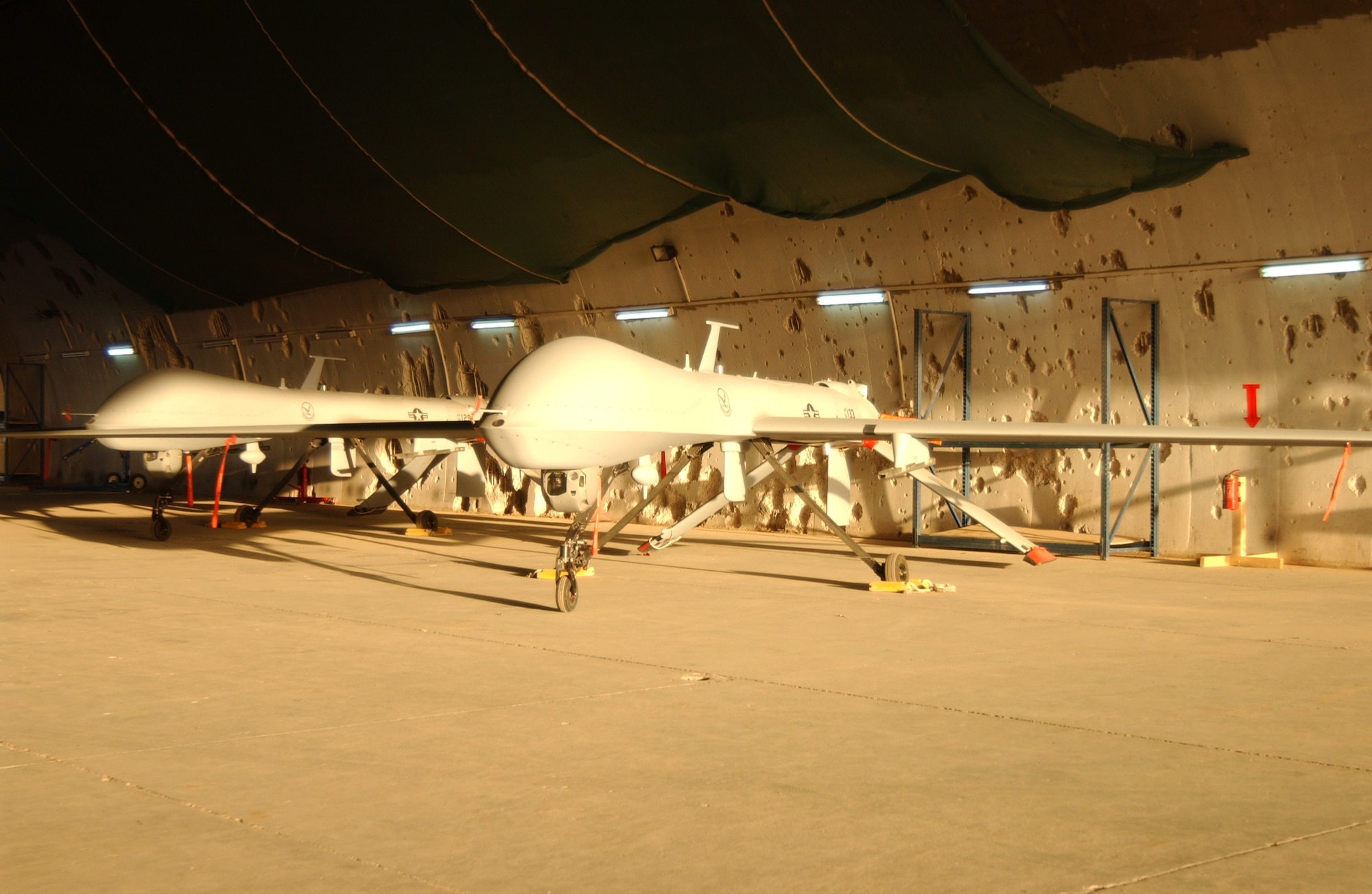 An MQ-1 Predator sits in a hardened aircraft shelter Monday at Balad Air Base, Iraq.  The 332d Air Expeditionary Wing here is home to the largest operational Predator squadron in the world, operating about 20 of the aircraft.  The shelter still bears the pock marks from U.S. attacks at the opening of Operation Iraqi Freedom (U.S. Air Force photo/SrA Kerry Solan-Johnson).