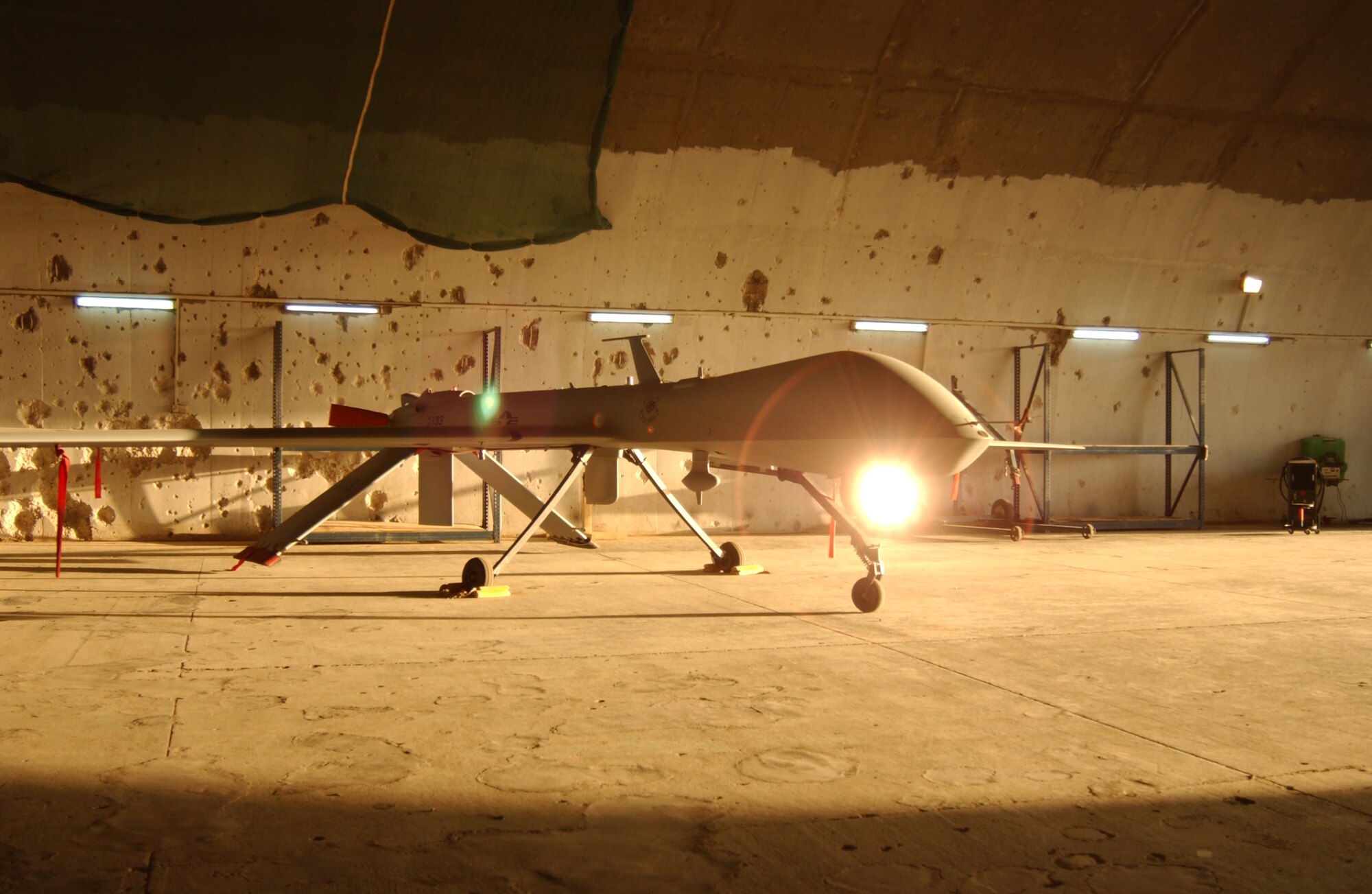 An MQ-1 Predator sits in a hardened aircraft shelter Monday at Balad Air Base, Iraq.  The 332d Air Expeditionary Wing here is home to the largest operational Predator squadron in the world, operating about 20 of the aircraft.  The shelter still bears the pock marks from U.S. attacks at the opening of Operation Iraqi Freedom (U.S. Air Force photo/SrA Kerry Solan-Johnson).