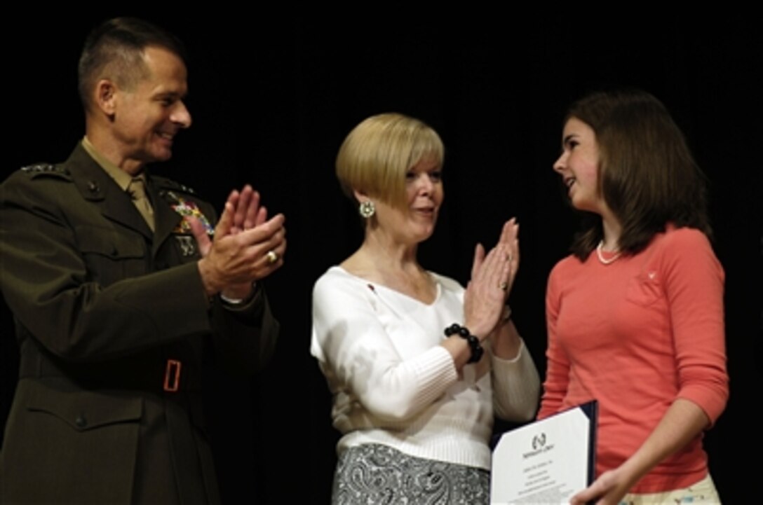 U.S. Marine Corps Gen. Peter Pace, chairman of the Joint Chiefs of Staff, and his wife Lynn, congratulate Clare Lanigan, 15, Kids Serve Too youth co-chair, for winning a $7,500 grant during the 2006 Newman’s Own Award Ceremony at the Pentagon, Washington, D.C., Aug. 11, 2006.  Kids Serve Too, in partnership with Warner Brothers, spearheaded “A Thousand Thanks to Military Children,” sending letters of thanks signed by a wide range of children’s characters to children of deployed military members 