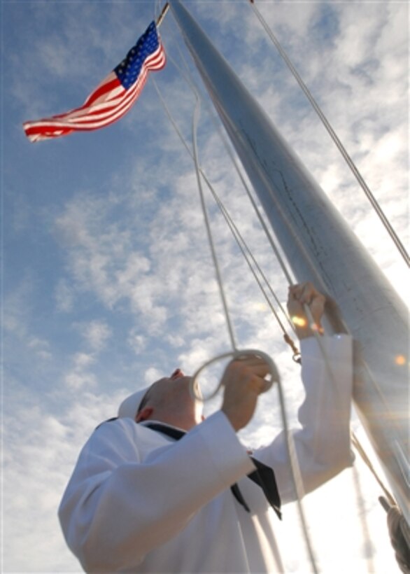 U.S. Navy Seaman Todd Lassiter raises the national ensign during morning colors at Commander, Naval Forces Marianas in Santa Rita, Guam, on Aug. 7, 2006.  Lassiter is assigned to Naval Facilities Engineering Command Marianas as a postal clerk.