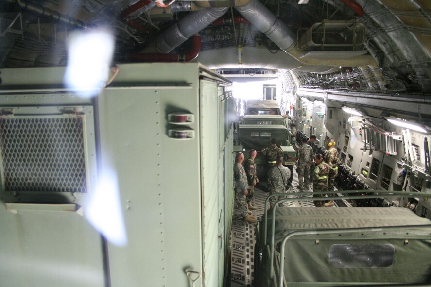 An inside view of vehicles, equipment and soliers from the Army's 304th Sustainment brigade being loaded onto a C-17 Globemaster III from March Air Reserve Base on July15, 2006 at Pt Mugu Naval Air Station, Calif. The primary mission is to move the 304th SBDE from Pt Mugu to March Air Reserve Base.The exercise included training for command and control, air to ground airlift and tanker communications, equipment preparation, joint inspection and rapid simultaneous onload of 5 C-17 chalks of outsized cargo and maintenance recovery and parking planning. (USAF photo by Staff Sgt. Amy Abbott)