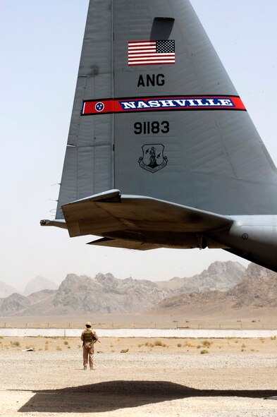 Senior Airman Charles Coles stands guard while a C-130 Hercules is unloaded at a remote airstrip near Farah, Afghanistan, on Aug. 10. Airman Coles is part of the 455th Expeditionary Security Forces Squadron's Fly-Away Security Team, which provides security for aircraft wherever they land in support of Operation Enduring Freedom. (U.S. Air Force photo/Maj. David Kurle)