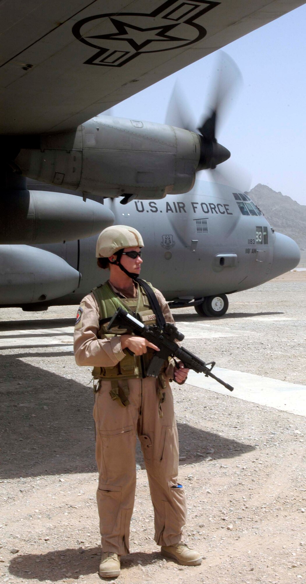 Staff Sgt. Gloria Banks watches for suspicious activity while guarding a C-130 Hercules at an airstrip near Farah Afghanistan, Aug. 10. She is part of the 455th Expeditionary Security Forces fly-away security team, which provides force protection for aircraft and crews throughout Afghanistan.  (US Air Force photo/Maj. David Kurle)