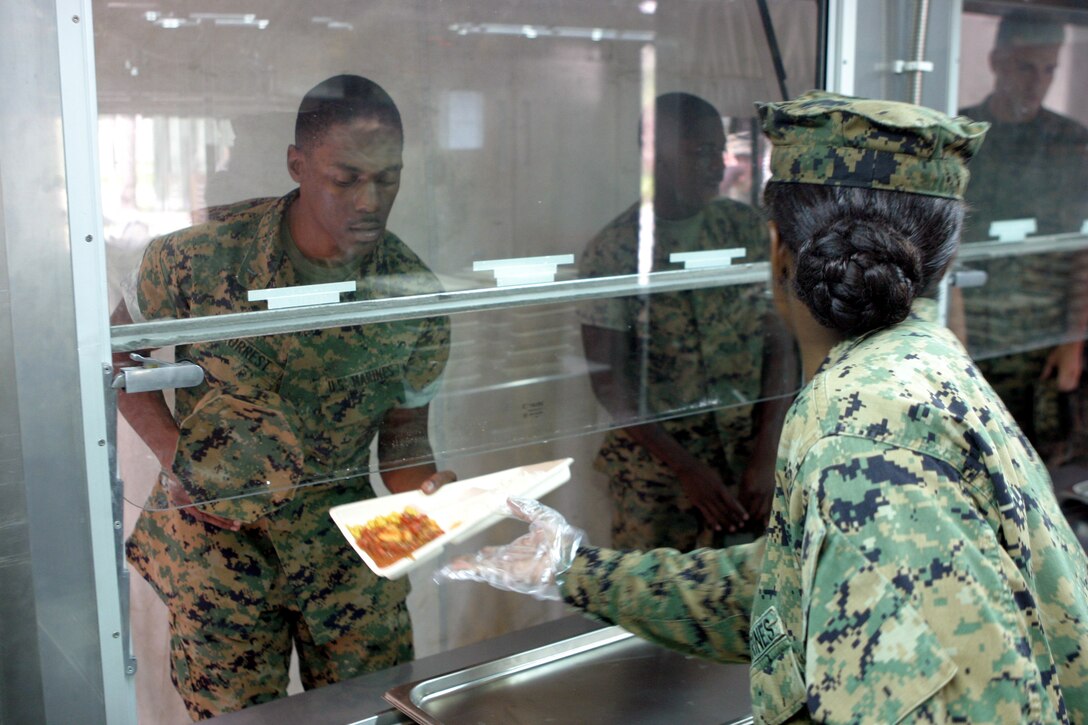 MARINE CORPS BASE CAMP LEJEUNE, N.C. (Aug. 14, 2006) - Food service specialists with Food Service Company, Headquarters Battalion, Combat Logistics Regiment 27, 2nd Marine Logistics Group, serve Marines at their field dining facility at Training Zone Owl, Aug. 14. The facility was built in preparation for the Maj. Gen. W. P. T. Hill Memorial Award for Food Service Excellence.