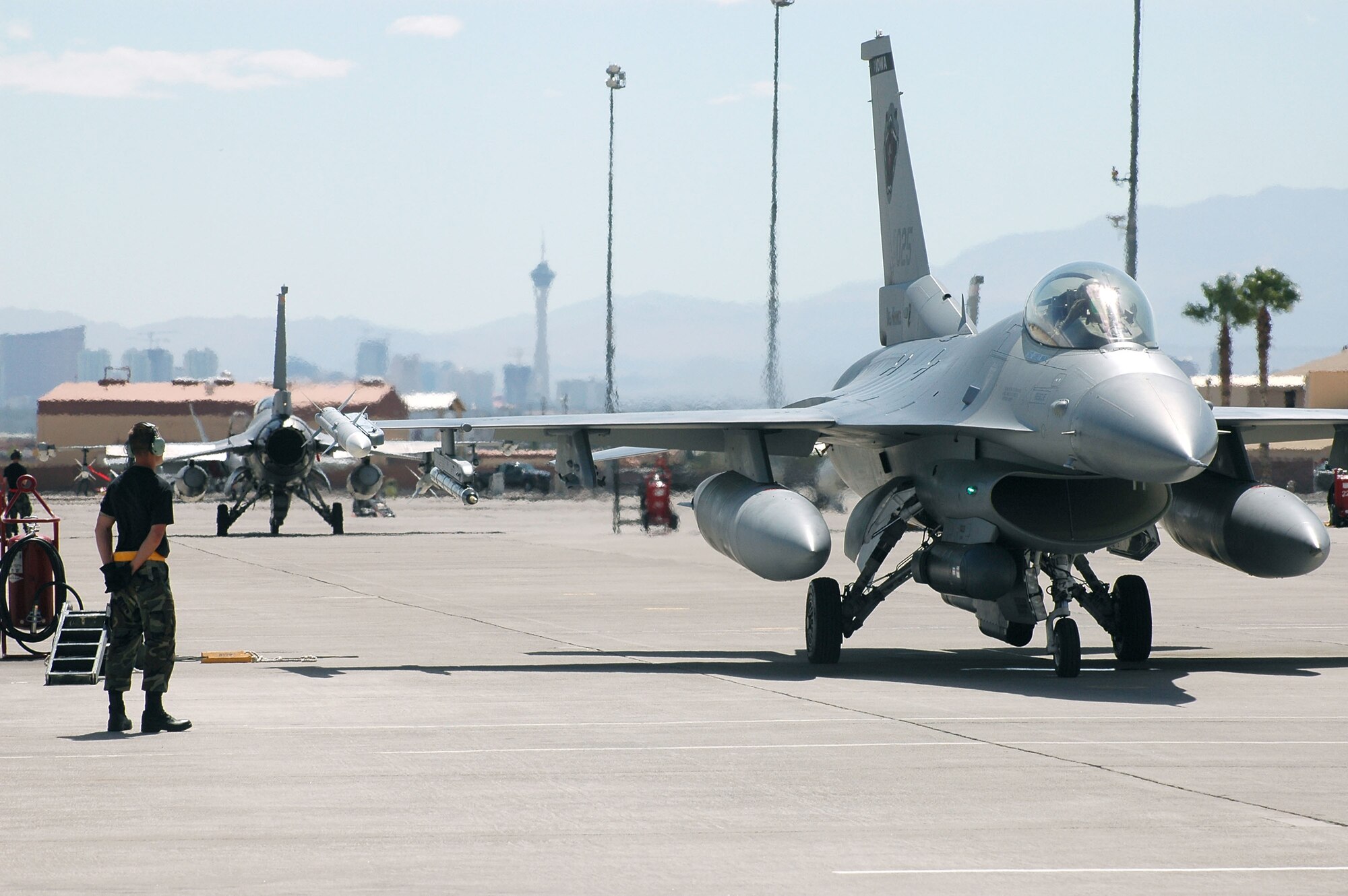 Senior Airman Ryan Stott prepares to marshal an F-16 Fighting Falcon that is ready for a mission at Red Flag 06-02 at Nellis Air Force Base, Nev., on Aug. 8.  Airman Stott is a crew chief with the Iowa Air National Guard's 132nd Fighter Wing in Des Moines.  (U.S. Air Force photo/Tech.Sgt. Bob Sommer)