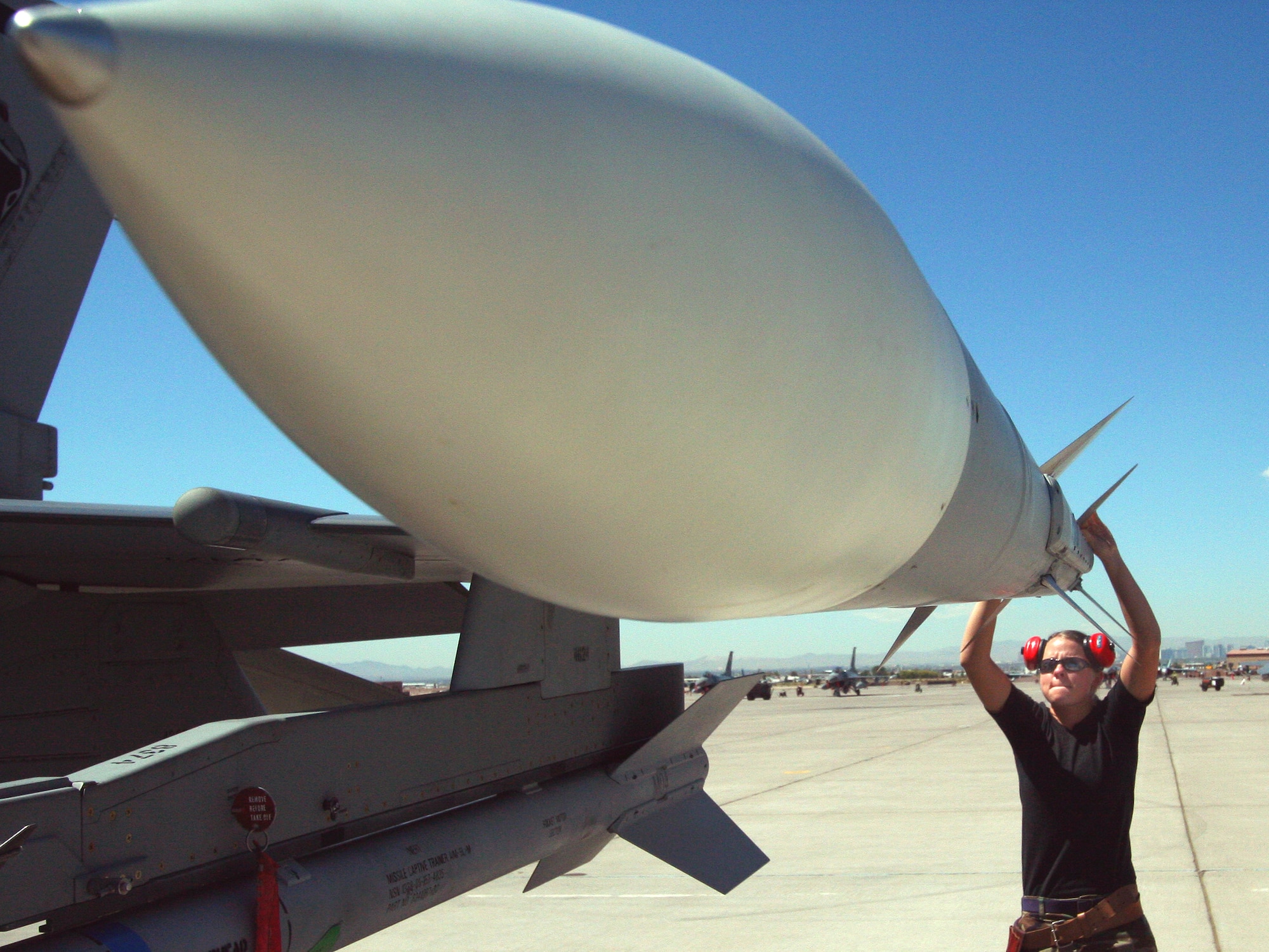 Staff Sgt. Jessica Srigley inspects an AIM-120 missile on an F-16 Fighting Falcon that is being readied for a mission at Red Flag 06-02 at Nellis Air Force Base, Nev., on Aug. 8.  Sergeant Srigley is a maintainer with the Iowa Air National Guard's 132nd Fighter Wing in Des Moines.  (U.S. Air Force photo/Tech. Sgt. Patrick M. Kuminecz)