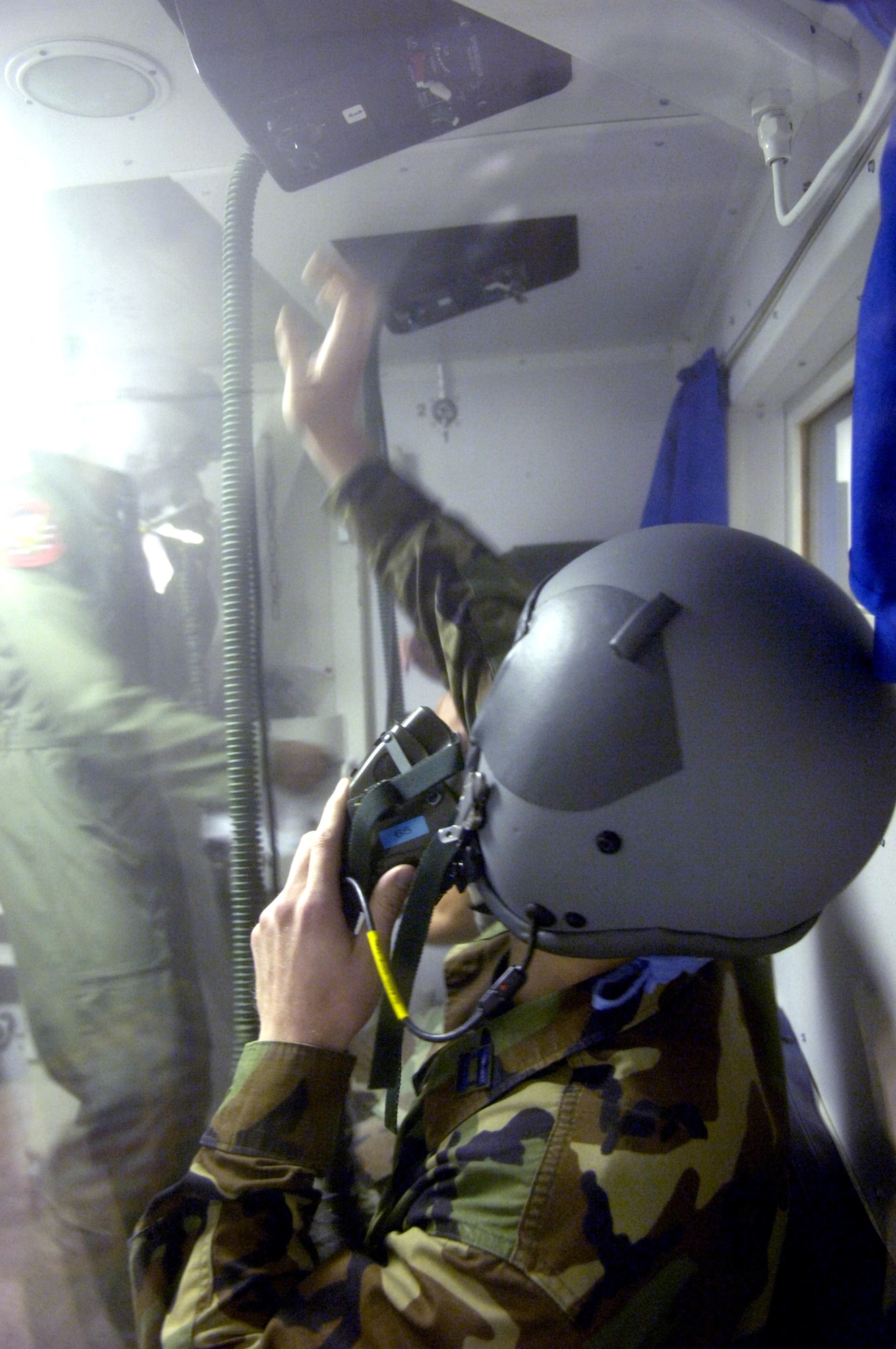 A student reaches to put his oxygen regulator on 100 percent oxygen during the rapid decompression portion of physiological training at Peterson Air Force Base, Colo., on Aug. 9. Physiological training is taught by Airmen at the 21st Aerospace Medical Squadron and provides students a better understanding of survival in the flight environment. (U.S. Air Force photo/Tech. Sgt. Shane A. Cuomo)