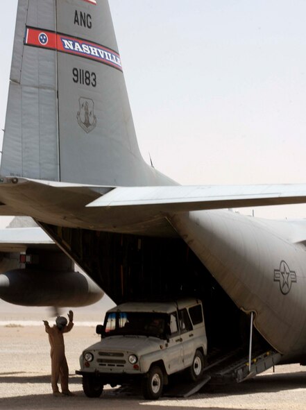 Master Sgt. Jeff Springsteen directs a four-wheel drive vehicle off the ramp of a C-130 Hercules on Aug. 10 at a dirt airstrip in the Farah Province of Afghanistan. C-130s, based at Bagram Air Base, Afghanistan, provide the majority of airlift and airdrop to re-supply U.S. and coalition forces in Operation Enduring Freedom. The 774th Expeditionary Airlift Squadron at Bagram is manned by Air National Guard units from Delaware, Alaska, Tennessee, Texas, Nevada, Wyoming, Arkansas and Puerto Rico. Sergeant Springsteen is a C-130 loadmaster deployed to the 774th EAS from the Delaware Air National Guard's 142nd Airlift Squadron. (U.S. Air Force photo/Maj. David Kurle)