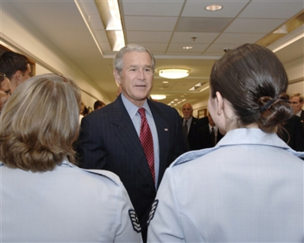 President George W. Bush talks to two Air Force airmen after his meeting and lunch with Secretary of Defense Donald H. Rumsfeld and his national security team in the Pentagon on Aug. 14, 2006. Vice President Dick Cheney, Secretary of State Condoleezza Rice, Chairman Joint Chiefs of Staff Gen. Peter Pace, U.S. Marine Corps, and Deputy Secretary of Defense Gordon England joined Bush and Rumsfeld to discuss the way ahead in Iraq and the war on terror.  