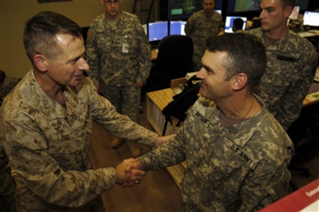 Chairman of the Joint Chiefs of Staff Marine Gen. Peter Pace gives a coin to a U.S. Army soldier during a visit to Camp Liberty, Iraq, Aug. 12, 2006. Pace is in Iraq to meet with U.S. military commanders and visit the troops. 