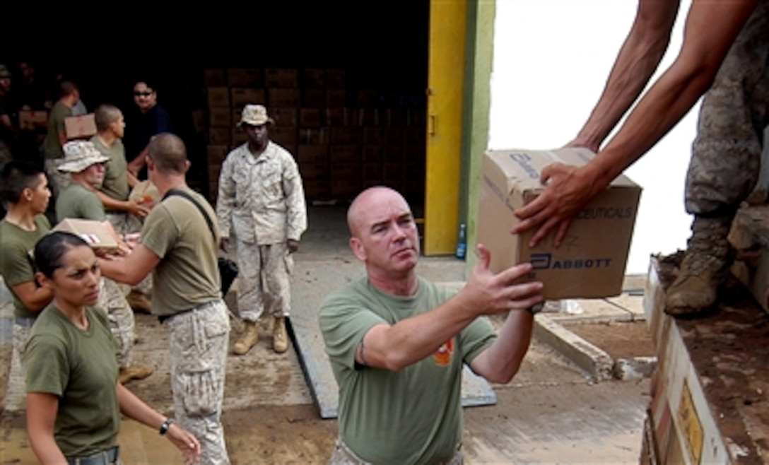 U.S. Marine Corps First Sgt. Robert Hamilton, center, unloads supplies at the heaquarters of exercise Natural Fire 2006 in Nginyang, Kenya, Aug. 4, 2006. The exercise is the largest held between East African Community nations and the United States and consists of military-to-military training as well as medical, veterinary, and engineering civic affairs programs conducted in rural areas throughout the region.