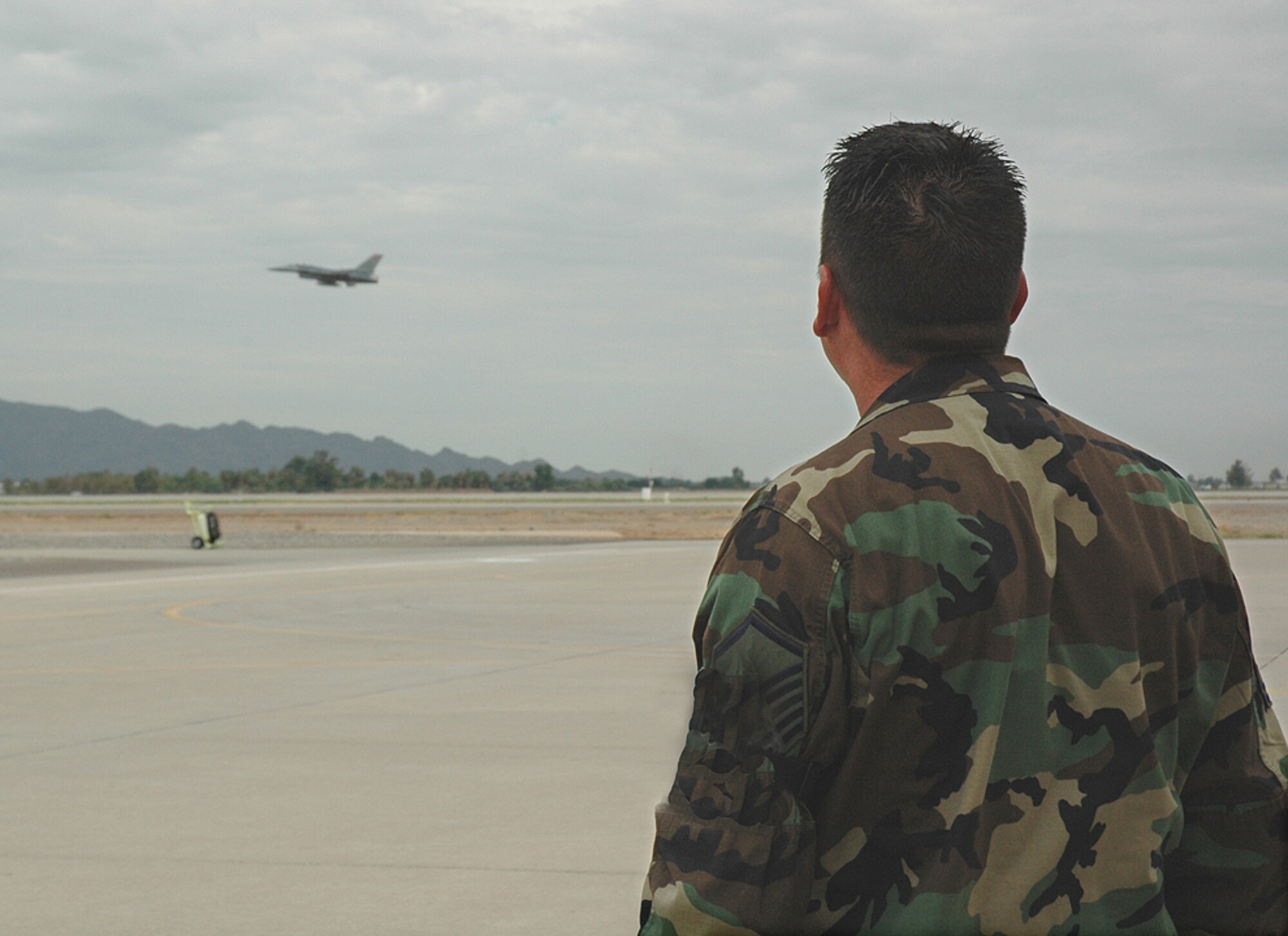 Master Sgt. Rob Taylor, 944th Maintenance Group crew chief, watches as tail number 86-273 takes off Aug. 15 to Hill Air Force Base, Utah. Sergeant Taylor was the first crew chief who accepted that jet when it arrived at Luke from the 64th Aggressor Squadron at Nellis Air Force Base, Nev., in 1991. The aircraft is the first of the 944th Fighter Wing's 17 F-16s that are being reassigned as part of Base Realignment and Closure. (U.S. Air Force photo/Staff Sgt. Stephen Razo)