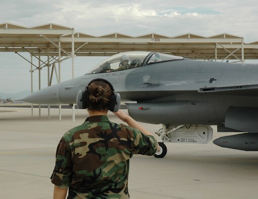 Senior Airman Faye Escobedo, 944th Aircraft Maintenance Squadron, salutes as Maj. Scott Crogg, 302nd Fighter Squadron pilot, taxis onto the flightline Aug. 15 at Luke Air Force Base, Ariz. Tail number 86-273 flew to Hill Air Force Base, Utah, where it will undergo Falcon Star, a life extending set up of upgrades. Following these upgrades, the F-16 will go to its new home at Nellis Air Force Base, Nev. This F-16 is the first of the 944th Fighter Wing's 17 F-16s that are being reassigned as part of Base Realignment and Closure. (U.S. Air Force photo/Staff Sgt. Stephen Razo)