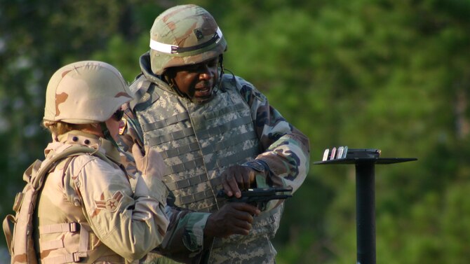 CAMP SHELBY, Miss - Airman First Class Natalie Anderson gets instruction from a soldier  at an M-9 firing range here.  Airman Anderson is part  of a team of 100 Airmen in pre-deployment training at Camp Shelby.  (Air Force photo by TSgt. Chris Vadnais)
