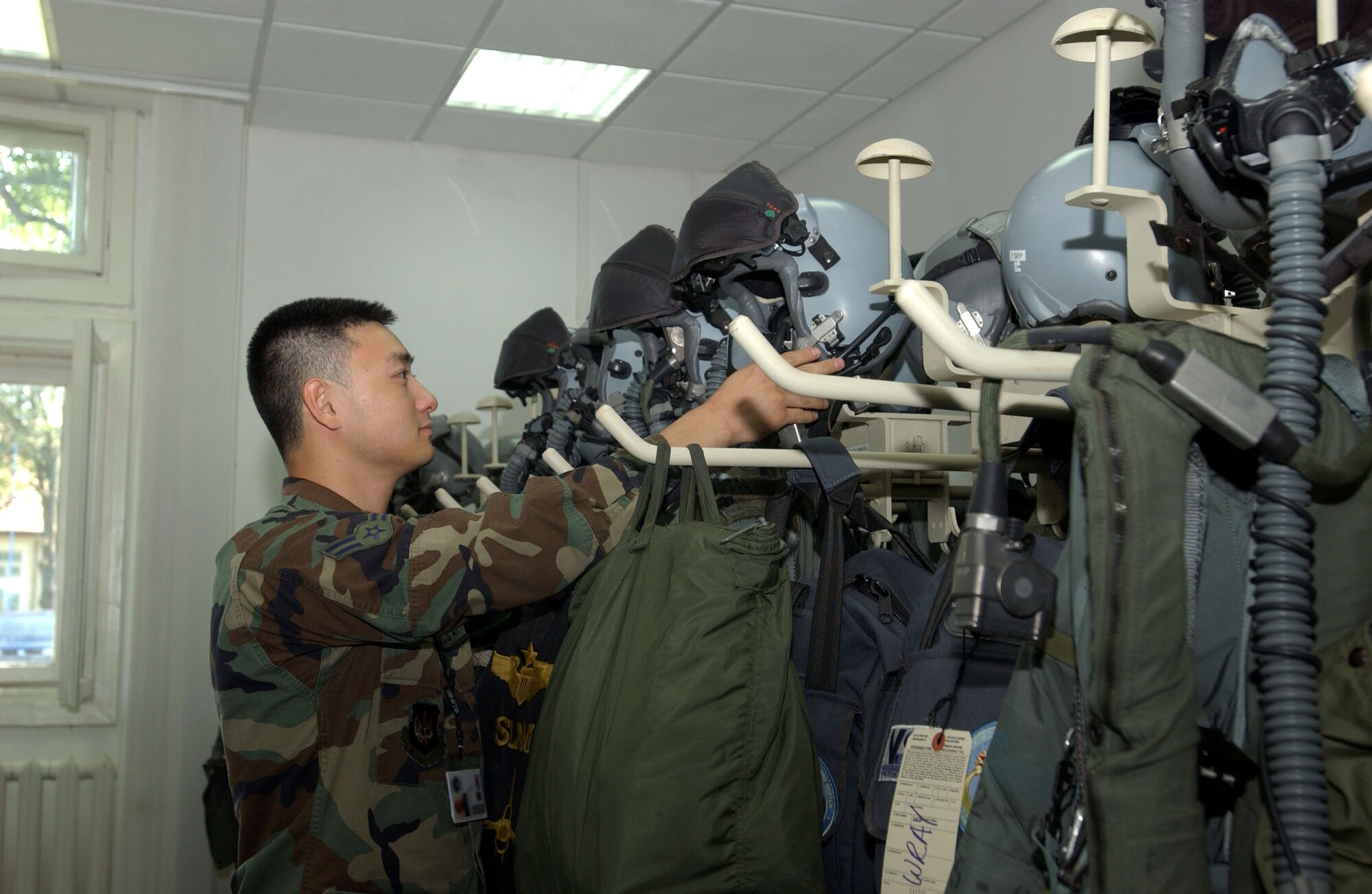 MIHAIL KOGALNICEANU AIR BASE, Romania -- Airman 1st Class David Chun, 22nd Expeditionary Fighter Squadron life support technician, places helmets worn by F-16 Fighting Falcon pilots on pegs Aug. 9. Airman Chun is here in support of VIPER LANCE 2006. (U.S. Air Force Photo/Senior Airman Eydie Sakura)