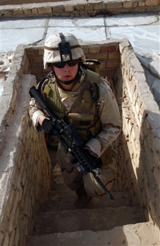 U.S. Navy Petty Officer 2nd Class Jeffery Kraus checks the roof of a house for illegal weapons during a house raid in Baghdad, Iraq, on Aug. 11, 2006.  