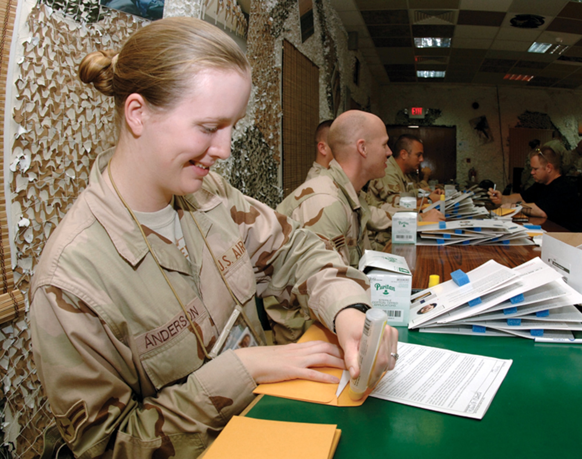 Airman 1st Class Christina Anderson seals a registration packet during a bone marrow donor registration drive at a forward operating base in Southwest Asia. The drive was organized by a deployed Airman in memory of her son, who lost his battle with acute lymphoblastic leukemia last September. The drive drew 685 new registrants to the national donor registry. Airman Anderson is with the 379th Air Expeditionary Wing. (U.S. Air Force photo/Master Sgt. Douglas Lingefelt)