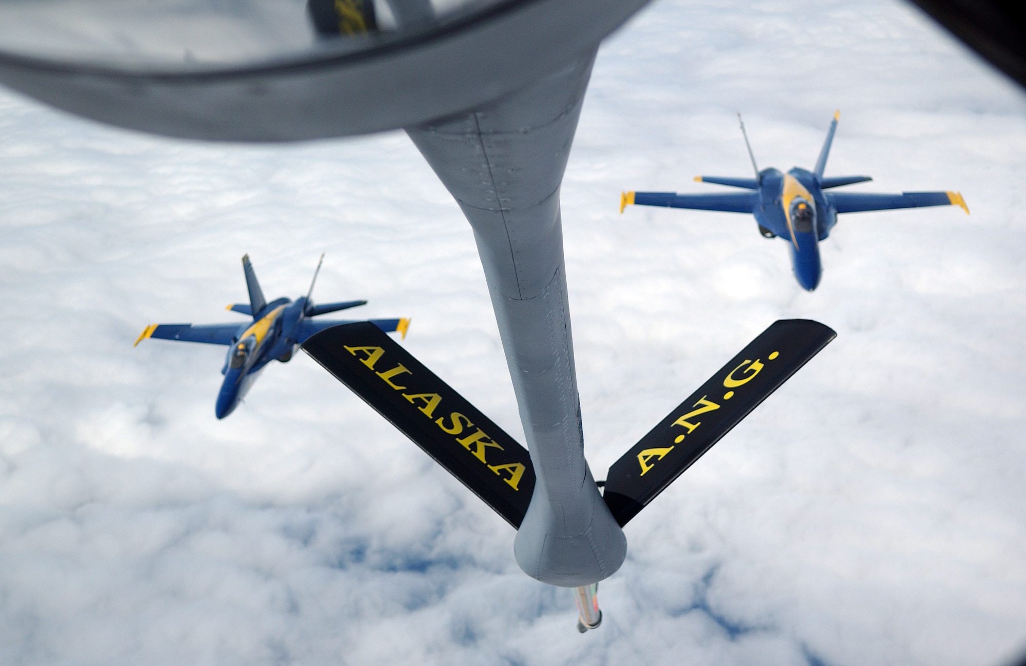 A KC-135 Stratotanker stands by to refuel a pair of F/A-18 Hornets from the Navy's Blue Angels on their way from an air show at Elmendorf Air Force Base, Alaska, on Aug. 14. The KC-135 is with the 168th Air Refueling Wing at Eielson AFB, Alaska. (U.S. Air Force photo/Senior Airman Anthony Nelson Jr.)

