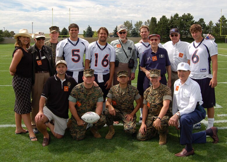 Marines from the Marine Cryptologic Support Battalion at Buckley Air Force Base in Colorado pose for a photo with representatives from the Greatest Generations Foundation, World War II veterans and quarterbacks from the Denver Broncos Aug. 9 at a Denver Broncos training camp practice. Pictured are: back row, left to right are: Elizabeth Crony, Lucky McGinty, Sgt. Brian Geraghty, Preston Parsons, Jake Plummer, Ray Heap, Bradlee Van Pelt, Leonard McKinney, E.E. Mischler, and Jay Cutler. Kneeling, left to right: Timothy Davis, Staff Sgt. Richard Molnar, Sgt. Manuel Perez, Lance Cpl. Christopher Pickens, and Rigney Sackley. The Marines were invited to the practice by the Greatest Generations Foundation to meet with World War II Veterans. The Greatest Generations Foundation is a non-profit educational organization that raises money to fully fund trips for veterans to revisit the sites of their former battlefields. (Photo by Air Force Staff Sgt. Aaron Cram)