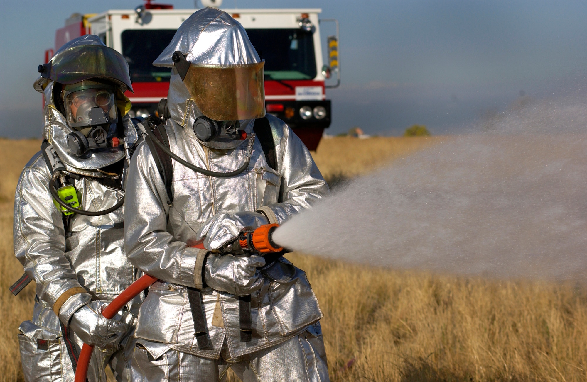 BUCKLEY AIR FORCE BASE, Colo. -- William Larosa and Jeremy Collette, firefighters with the 460th Civil Engineer Squadron, demonstrate putting out a fire at the scene of a simulated F-16 Fighting Falcon mishap during a full spectrum threat response exercise Oct. 6, 2005, at Buckley Air Force Base, Colo. (U.S. Air Force photo by Staff Sgt. Chenzira Mallory)
