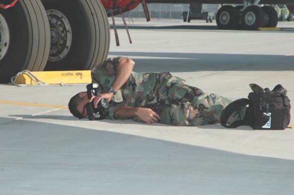 GRISSOM AIR RESERVE BASE, Ind -- Senior Airman Roberto Modelo, a publc affairs specialist with the 434th Air Refueling Wing, lays on the parking apron to get a unique angle for a photograph of a KC-135R Stratotanker. (U.S. Air Force photo/SrA Jonathan Jones)