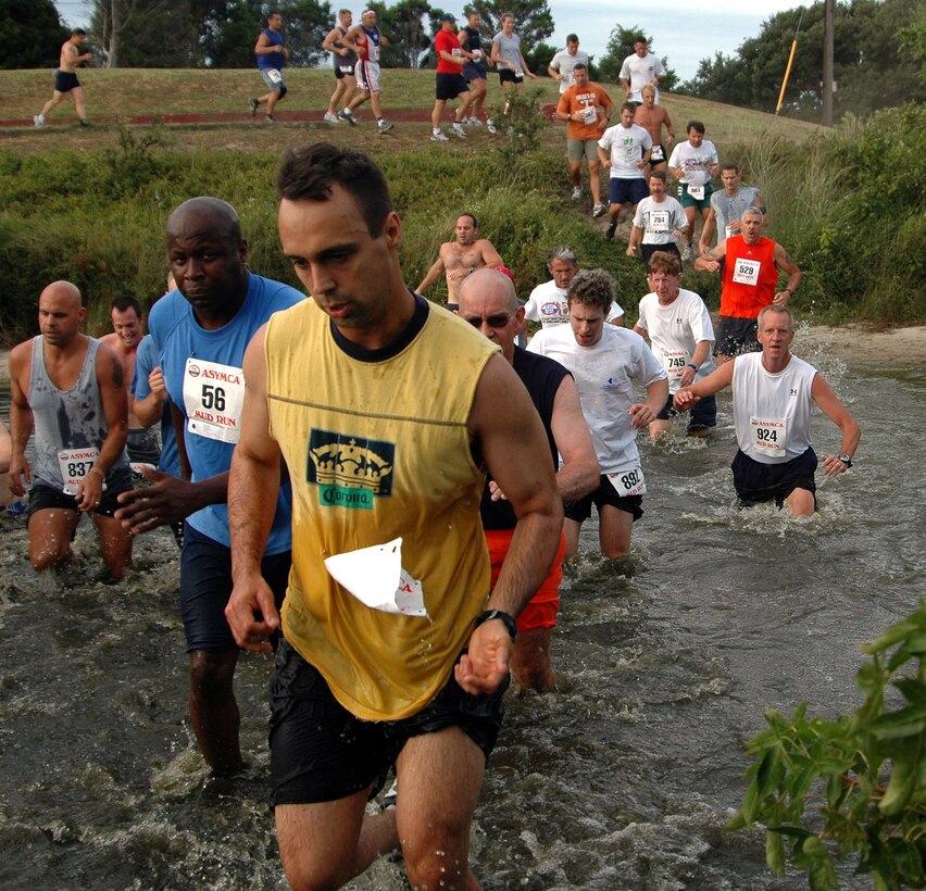 Participants of the 6th Annual Mud Run at Naval Amphibious Base Little Creek, Va., cross through their first obstacle in the course, Aug. 12, 2006. 