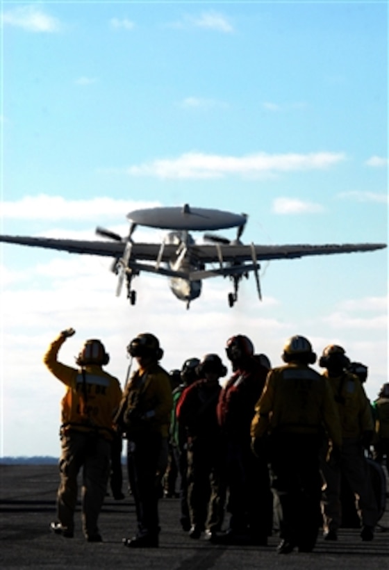 Flight deck crewman watch an E-2C Hawkeye aircraft climb after catapulting from the aircraft carrier USS Ronald Reagan (CVN 76) during flight operations in the Pacific Ocean on Aug. 15, 2006.  Reagan is off the coast of California performing seamanship and aviation training.  