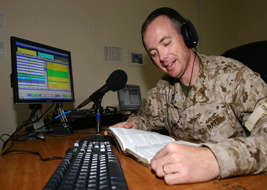 Navy Lt. Dan W. Hall records himself reading a scripture from the bible to be aired on the new religious programming radio station Aug. 16, at Al Asad, Iraq. Hall, a native of Memphis,Tenn., is the deputy chaplain for Marine Aircraft Group 16 (Reinforced), 3rd Marine Aircraft Wing. He deployed with his own low-power FM transmitter and computers to start a radio station that will broadcast religious music, devotionals, preaching and other programming giving people here another medium for spiritual health.