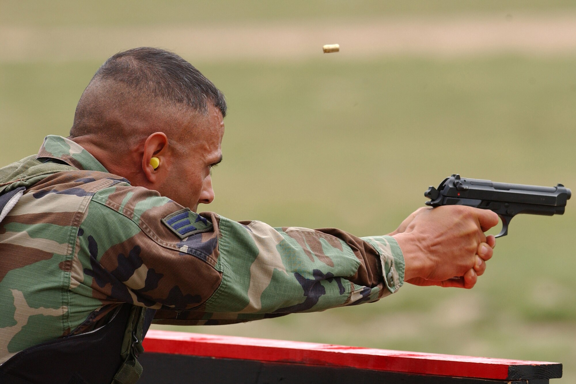 Senior Airman Romy Villescas of the 460th Security Forces Squadron, Buckley Air Force Base, Colo., fires a 9-mm pistol during the marksmanship portion of Guradian Challenge 2006.  