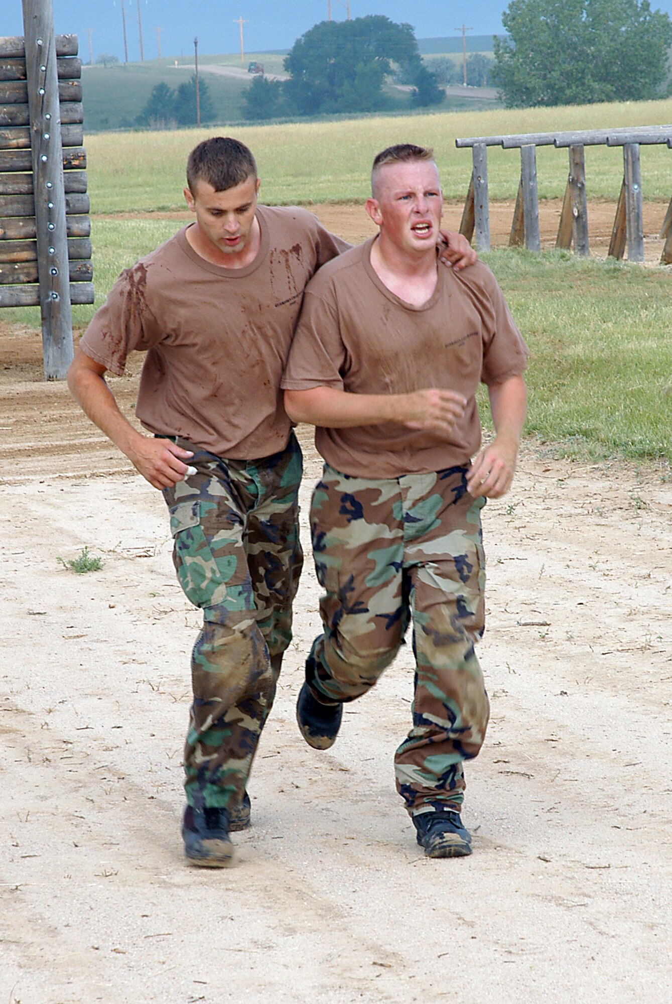 Tech. Sgt. Brian Johnson (left) runs alongside Staff Sgt. Scott Willis at the Guardian Challenge obstacle course Aug. 16. Sergeant Willis injured his ankle during the challenge, but team members stuck together through the end of the course in a display of wingmanship. The NCOs are with the 50th Security Forces Squadron at Schriever Air Force Base, Colo. (U.S. Air Force photo/Staff Sgt. Don Branum) 
