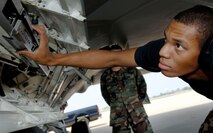 Airman 1st Class Lamond Janey inspects a missile launcher on an F-22 Raptor during a weapons load inspection at Langley Air Force Base, Va., on Aug. 15. Airman Janey is a weapons load crew member with the 27th Aircraft Maintenance Unit. (U.S. Air Force photo/Staff Sgt. Samuel Rogers) 
