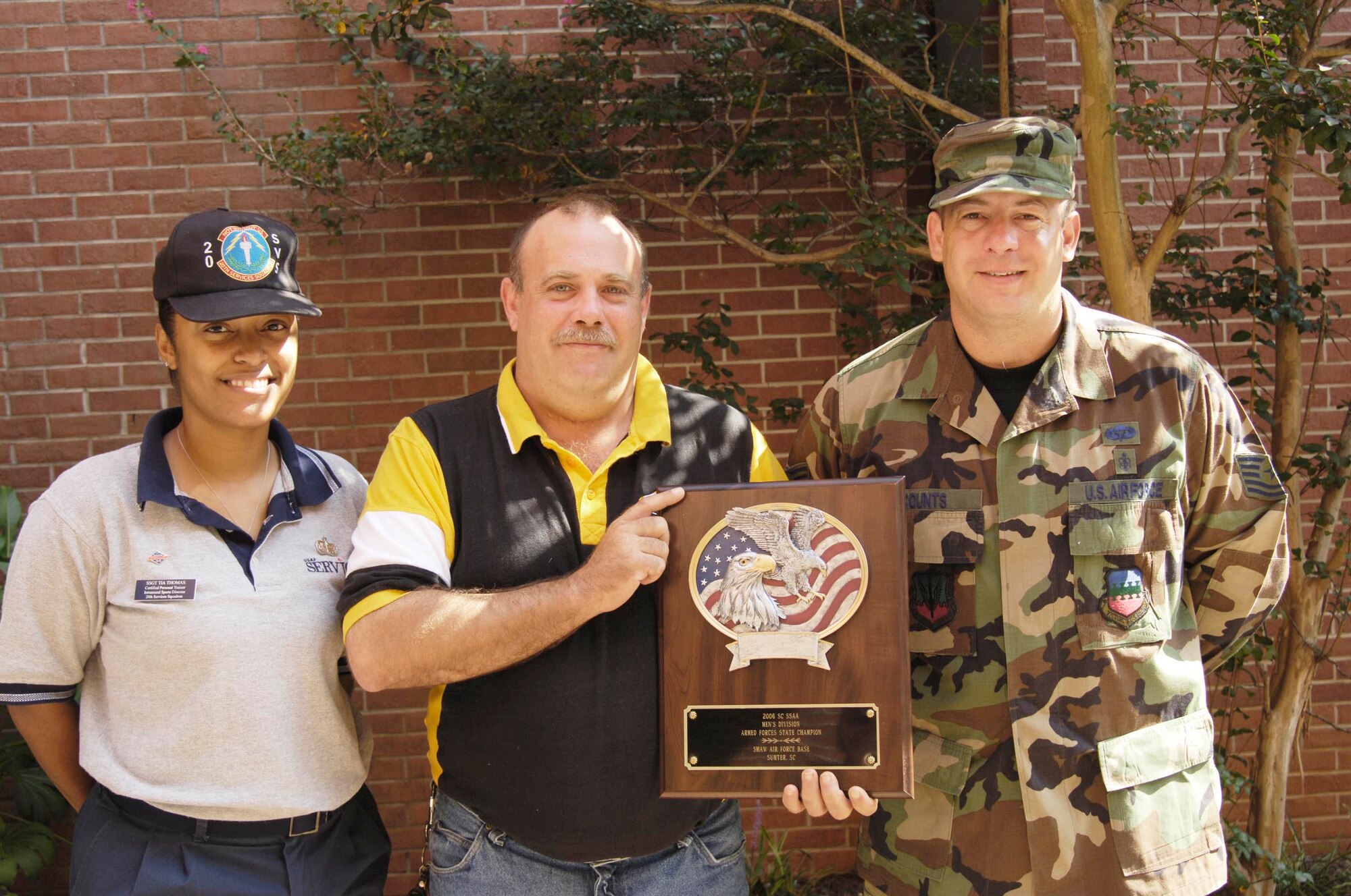 (From left) Staff Sgt. Tia Thomas, varsity director, and Brian Combs, southern softball association director, present coach Tech. Sgt. Jimmy Counts, 20th Aeromedical-Dental Squadron, Tuesday with an award for his team winning the South Carolina Armed Forces and State Championships. (U.S. Air Force photo/Airman 1st Class William Coleman)