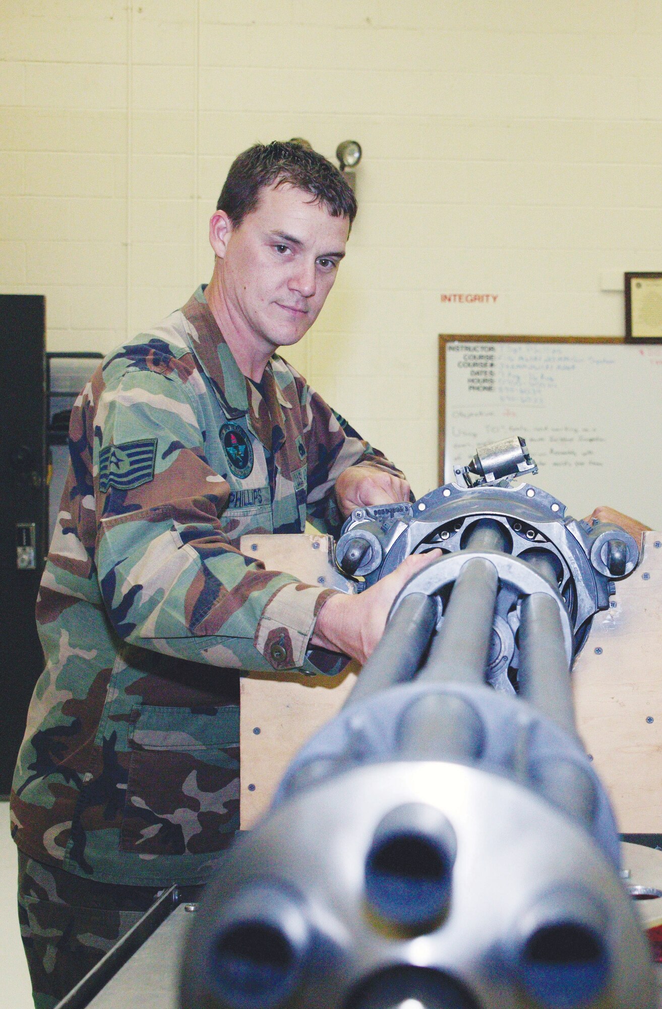 Tech. Sgt. Kenneth Phillips, 372nd Training Squadron Field Training Detachment instructor, demonstrates an ammunition hold-back tool on an F-16 weapons system Monday. (U.S. Air Force photo/Tarsha Storey)