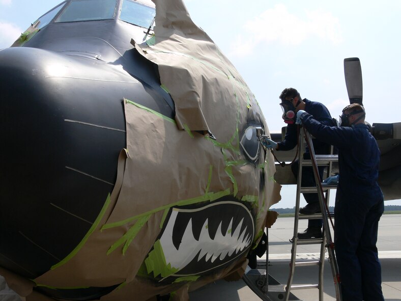 MOODY AIR FORCE BASE, Ga. -- Airmen 1st Class Ernesto Sosa and Nicholas Heimgartner, 347th Maintenance Squadron, paint the nose of a Moody C-130E Friday. The aircraft was repainted to represent the 347th Rescue Wing's upcoming transition to the 23rd Wing, known as the famous "Flying Tigers."  The 347th RQW will deactivate and the 23rd Wing will activate Oct. 1. (U.S. Air Force photo by Airman 1st Class Eric Schloeffel)