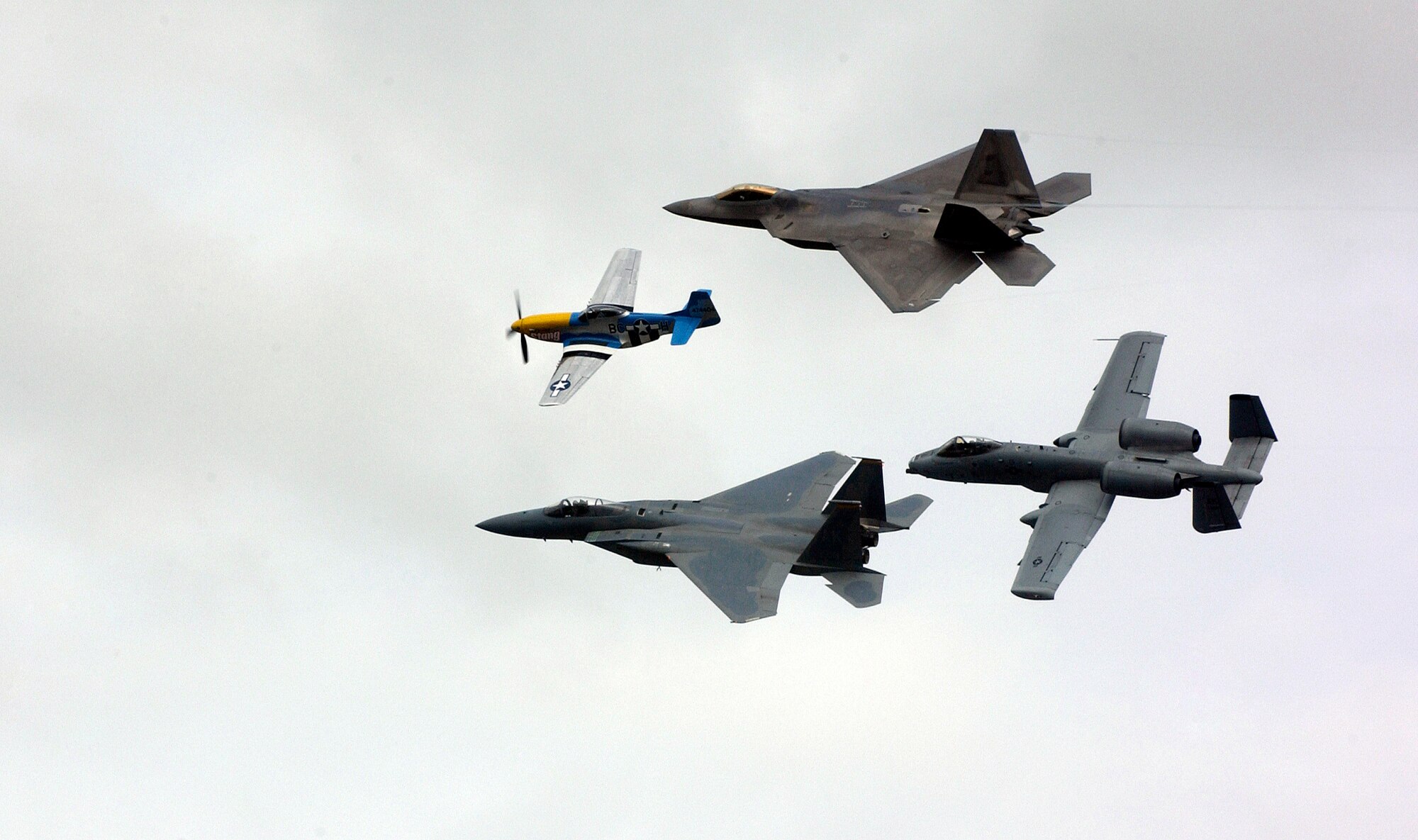 A heritage flight with a P-51 Mustang, F-15 Eagle, F-22 Raptor and A-10 Thunderbolt II fly over the crowd at the Arctic Thunder air show at Elmendorf Air Force Base, Alaska, on Aug. 12. The two-day event drew nearly 136,000 visitors. (U.S. Air Force photo/Airman Jonathan Steffen) 
