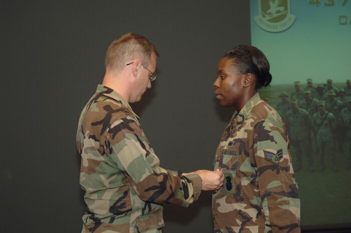 Maj. Paul Stang, 437th Security Forces Squadron commander, presents the Army Commendation Medal to Senior Airman Melyne Carson Aug. 11 (U.S. Air Force photo by James Bowman) 
