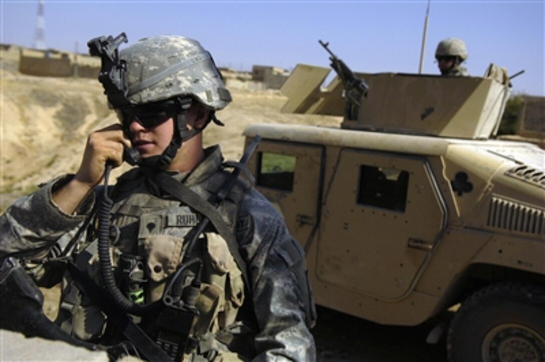 Army Spc. Andrew Ruhlman uses a radio to contact fellow platoon members during a patrol in Tall Afar, Iraq, on Aug. 12, 2006.  Ruhlman is attached to the1st Brigade Combat Team, 2nd Battalion, 37th Armored Regiment, 1st Armored Division.  