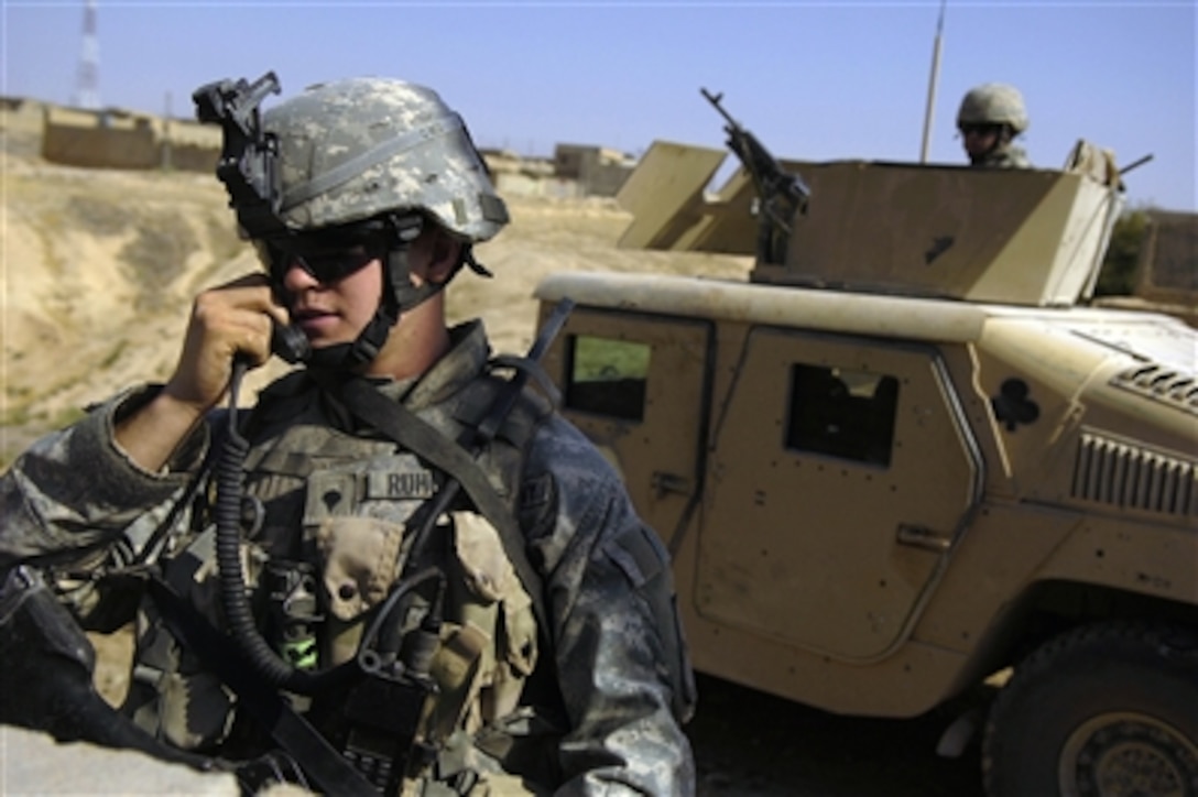 Army Spc. Andrew Ruhlman uses a radio to contact fellow platoon members during a patrol in Tall Afar, Iraq, on Aug. 12, 2006.  Ruhlman is attached to the1st Brigade Combat Team, 2nd Battalion, 37th Armored Regiment, 1st Armored Division.  